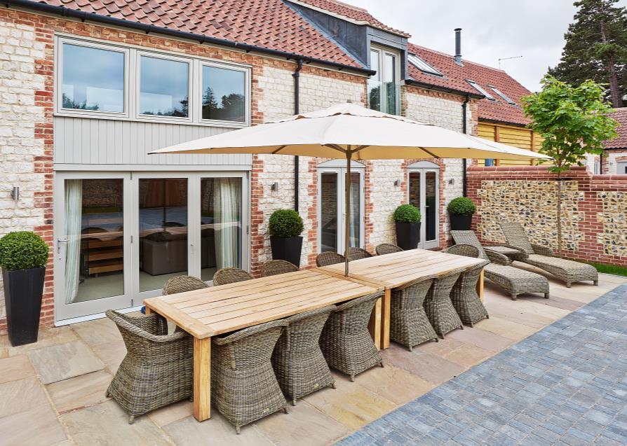 A further terrace area to the side of the property with an oak framed structure offering a covered seating area with power, lighting,