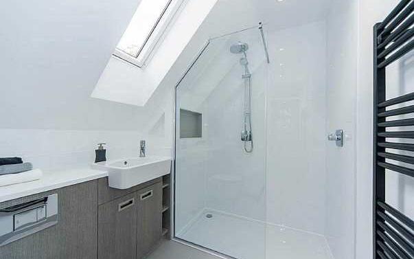 52m) Fitted with a white suite comprising shower cubicle with glass door and chrome wall mounted overhead monsoon style shower with hand held attachment, concealed cistern low level WC and wash