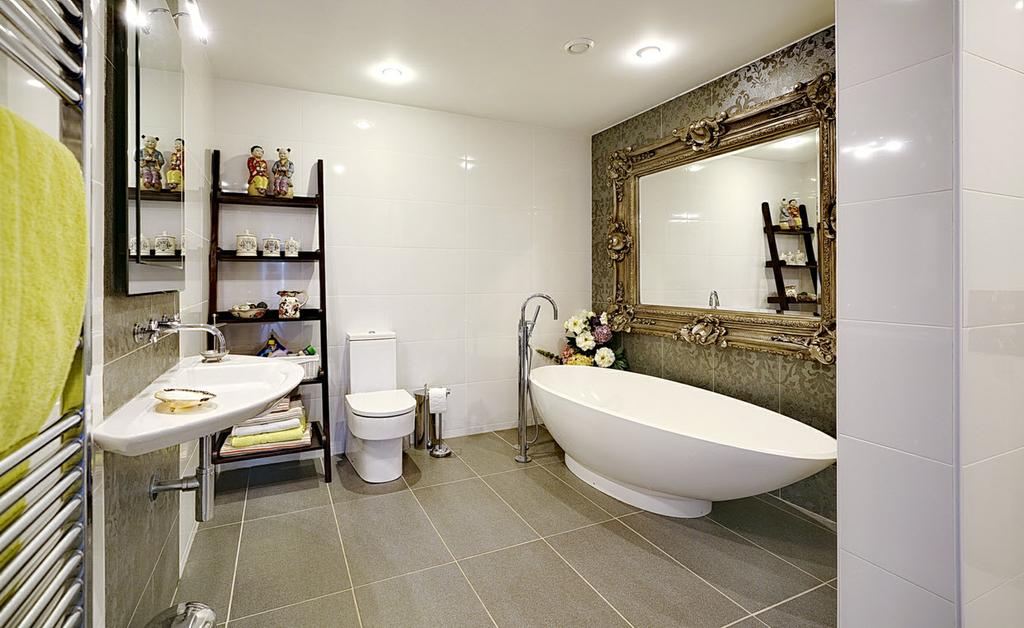 LUXURY BATHROOM: Oval free standing bath with mixer tap and telephone hand shower, contemporary wash hand basin with mixer tap, low flush wc, walk-in shower with thermostatic shower unit and rain