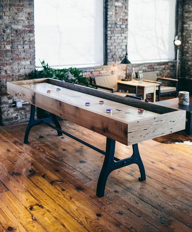 A PLAYFUL STATEMENT The iconic shuffleboard, framed in Reclaimed Oak, with a butcher block