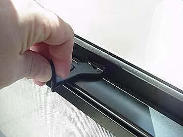 Press the catches outward toward the frames while lowering the window.