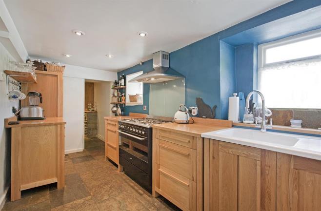 KITCHEN Six down lights to the ceiling, two double glazed windows to the front elevation, free standing solid oak kitchen, inset sink and drainer unit with