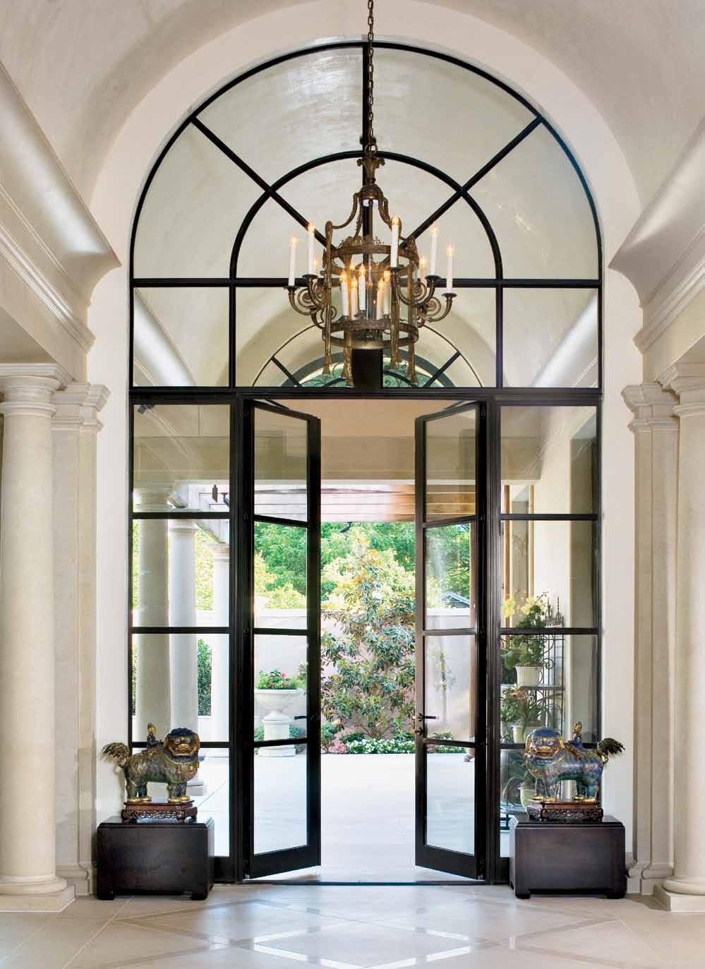 Custom steel-framed Hope s windows and doors alongside a barrel-vaulted ceiling, 10-foot-high Doric columns and Lueders limestone flooring laid in a diamond pattern contribute to this