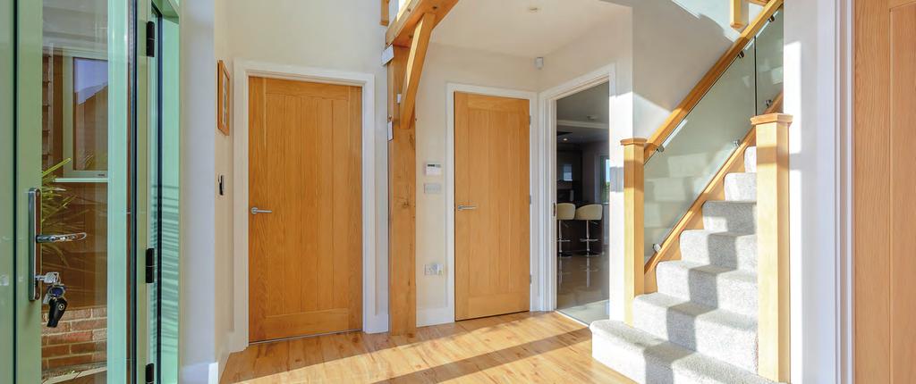 Front door with full-height window surrounds, with electric blinds to: ENTRANCE HALL Exposed oak beams. Staircase to first floor galleried landing with oak and glass balustrades.