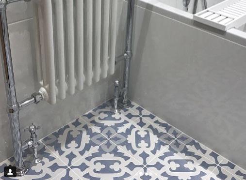 The feature radiator and bright white wall tiles complement the beautiful patterned tiles.