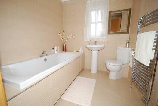 BATH & SHOWER ROOM with window to the front. Fully tiled. White suite.