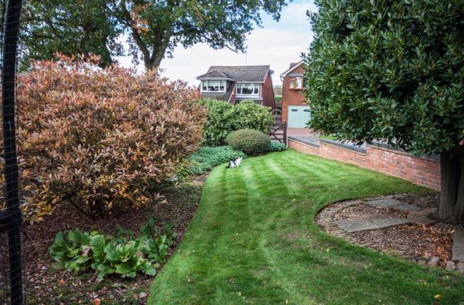 to the garage and rear entrance. To the rear of the garage is a brick built store, steps to a paved area with shed, additional garden store and further lawned garden with mature border & trees.