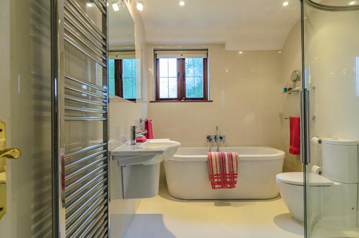 LUXURY FULLY TILED BATHROOM: Panelled bath, telescopic shower, corner shower cubicle with drencher shower head, low flush wc, heated towel rail, wash hand basin.