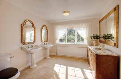 There s a suite in white, which comprises a low level WC, inset wash hand basin with chrome mixer tap, storage beneath and vanity mirror over, panelled bath with chrome mixer tap and an additional