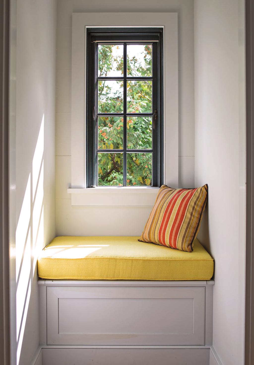 this photo: A narrow window with a seat brings much-needed light into the tunnellike staircase.