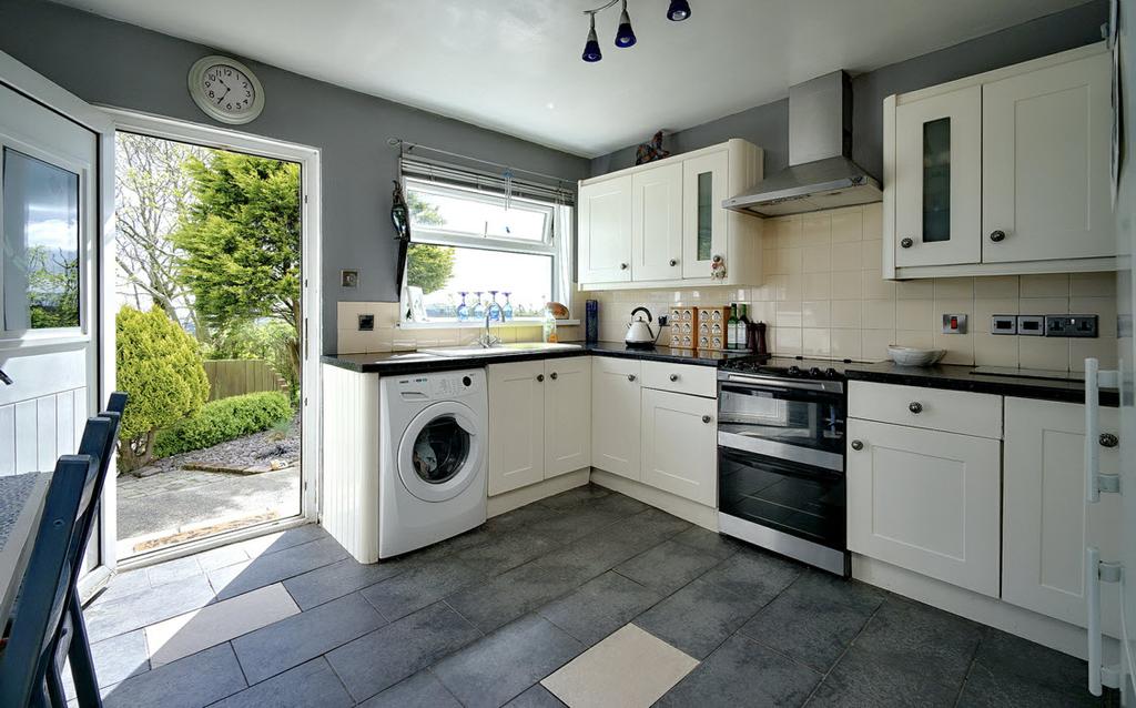 56m) Cream coloured kitchen with range of high and low level units,