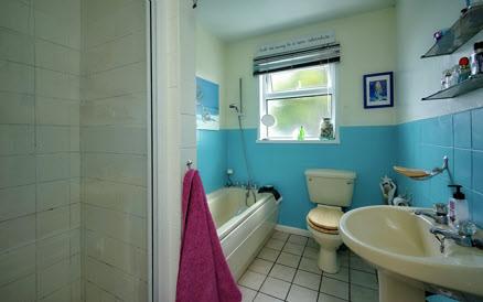 BATHROOM: Coloured bathroom suite comprising panel bath with mixer taps, low flush