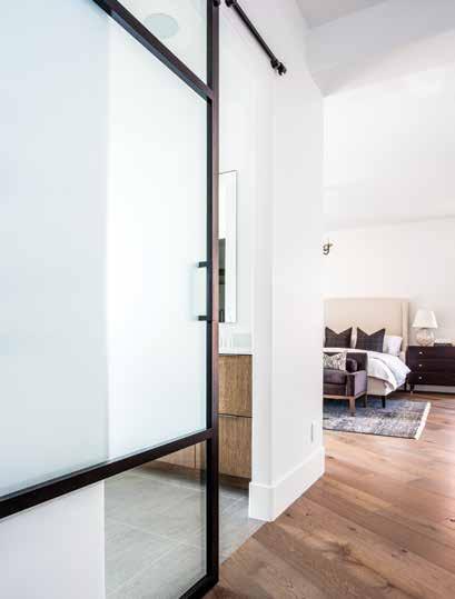 BOTTOM RIGHT: A modern barn door slides to close off the master bathroom from a wide hallway