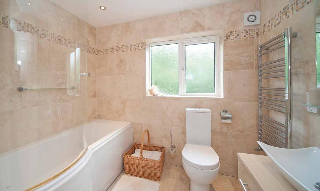Family Bathroom A modern three piece suite comprising panelled bath with shower over, vanity unit with wash hand basin, low level WC, feature tiled walls and flooring, double glazed window to front