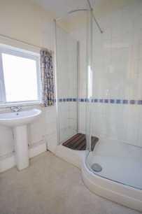 91m (10'2" x 6'3") Comprising: off-set panelled bath with mixer tap and shower attachment; low level WC; and worktop with storage beneath, inset wash hand basin and tiled