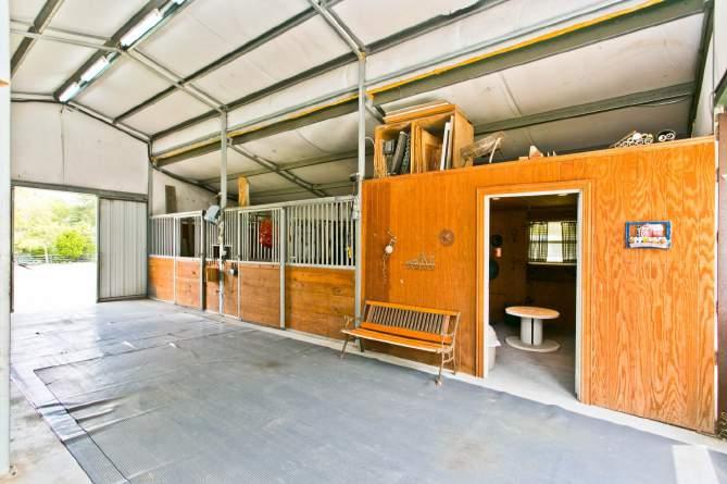 Sliding barn doors are on each end, two horse stalls, tack room, automatic water fill and