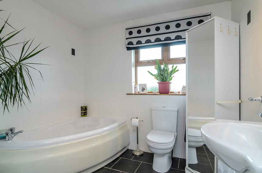46m) White suite comprising panelled corner bath with mixer taps, tiled shower