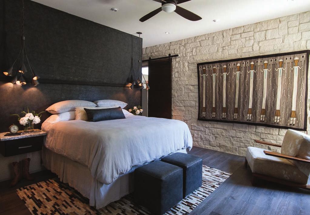The master retreat boasts a variety of textures including Austin limestone and a leather headboard wall by L Design Group and Diaz Upholstery.