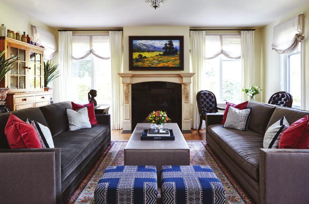 Two custom ottomans on hidden casters were designed to fit under the waterfall-style coffee table for extra seating. This historic home in Hanover has been in the family for several generations.