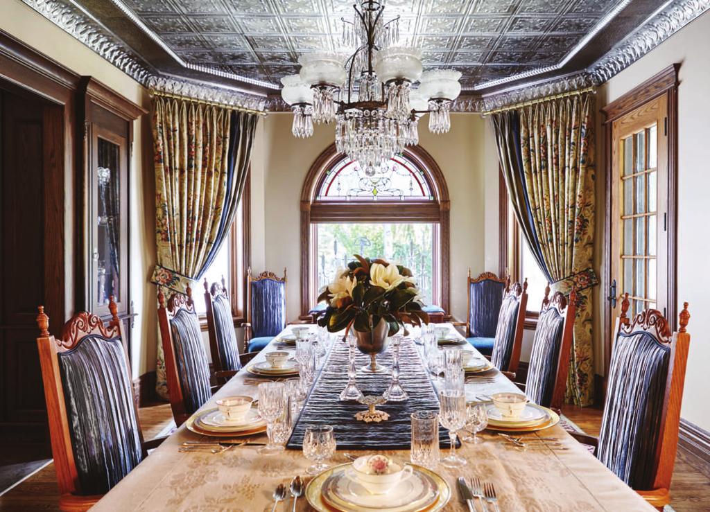 A stunning tin ceiling sets the mood for this extravagant dining room featuring soaring