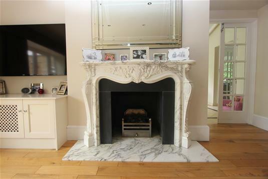A central focal point is an impressive carved ornate marble fireplace and hearth. Radiator. The drawing room and dining room are open to one another.