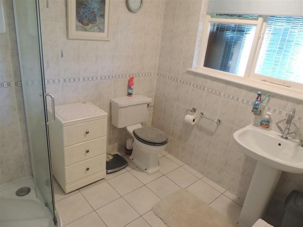 Downstairs Shower Room Fitted carpeted flooring. White painted walls. Wood panelled ceiling and skirting boards. Ceiling mounted lighting. Wall mounted white radiator.