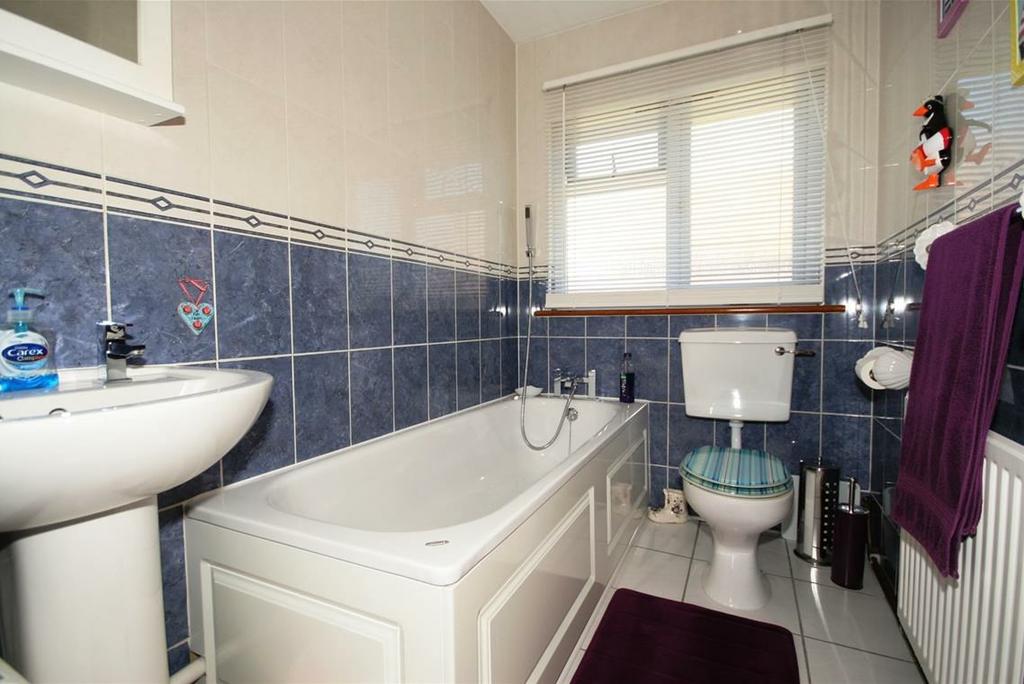 BATHROOM Being fully tiled comprising built in shower with separate shower attachment, wall mounted wash hand basin with contemporary style mixer tap,low level wc, single paneled radiator, frosted