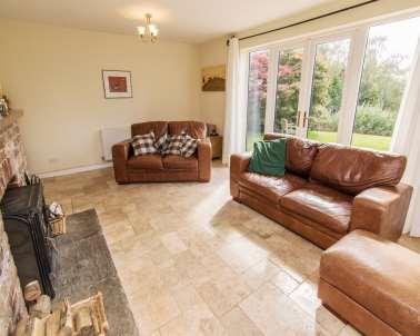 The bungalow briefly comprises a large entrance hallway, a very bright and attractive lounge which has a wood burner and views across the gardens and countryside, a fitted kitchen / dining room with