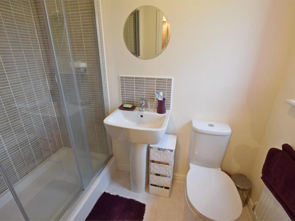 windows and enjoying a particularly pleasant view over neighbouring playing fields There are two ceiling lights, and two central heating radiators Door opens to: EN-SUITE SHOWER ROOM Comprising of a
