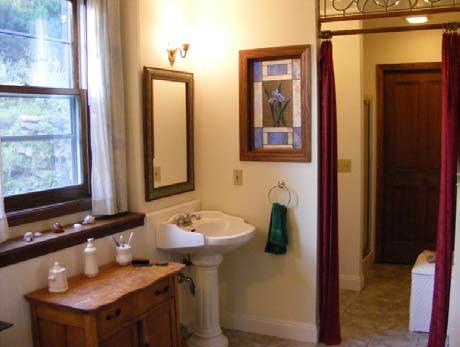 Shower/ toilet area separate from bath. Wood stove is visible from tub when door is left open.