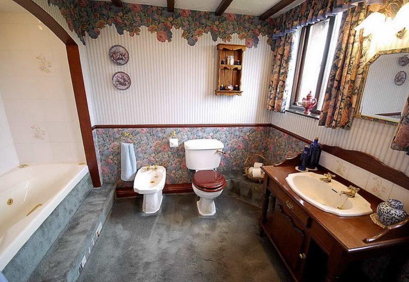 Family Bathroom Having dado rail decor and comprising of a 4 piece cottage suite comprising low flush WC, vanity wash basin set into feature oak wash stand, bidet and whirlpool bath with overhead