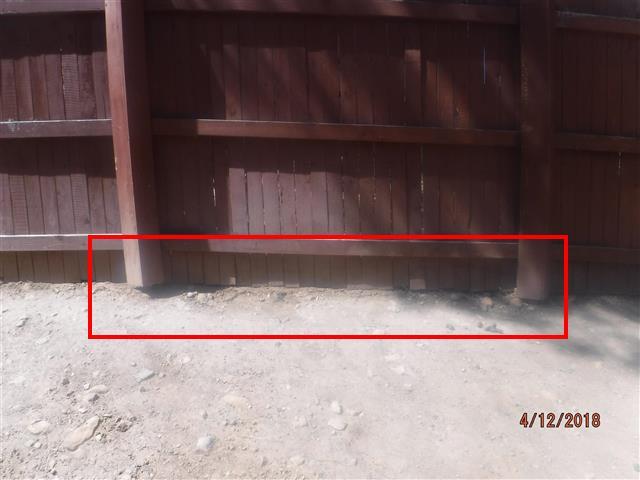 D. The rear fence is currently acting as a retaining wall.