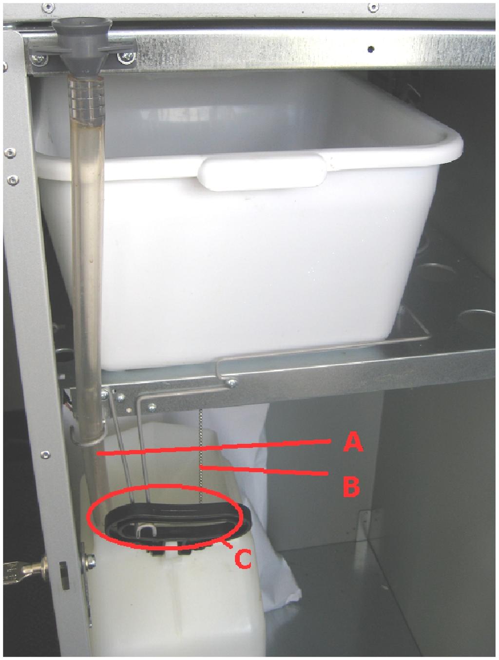 11. Open the lower metal base cabinet door with the round key, ensure the clear plastic drip tray hose (A) and waste container float/chain (B) are placed within the white waste water container (C) 12.