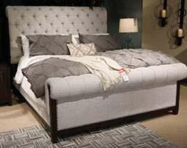 modern farmhouse group in a lively dark brown distressed wood finish that emulates the qualities of salvaged wood Upholstered bed with matching show wood frames has thick roll-top design Light gray
