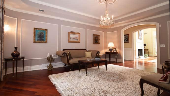 First Level Grand Two-Story Entrance Hall: Double mahogany doors open to breathtaking two-story entrance hall with 21 5 high ceiling, wired for chandelier in the middle of the grand tray ceiling,