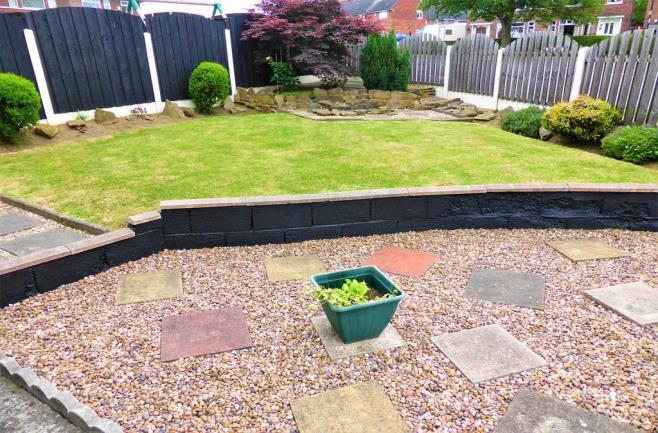 To the front of the property is a well landscaped, fenced garden offering a well manicured lawn, gravelled sections for colourful pots, well stocked borders and established trees and shrubs adding to