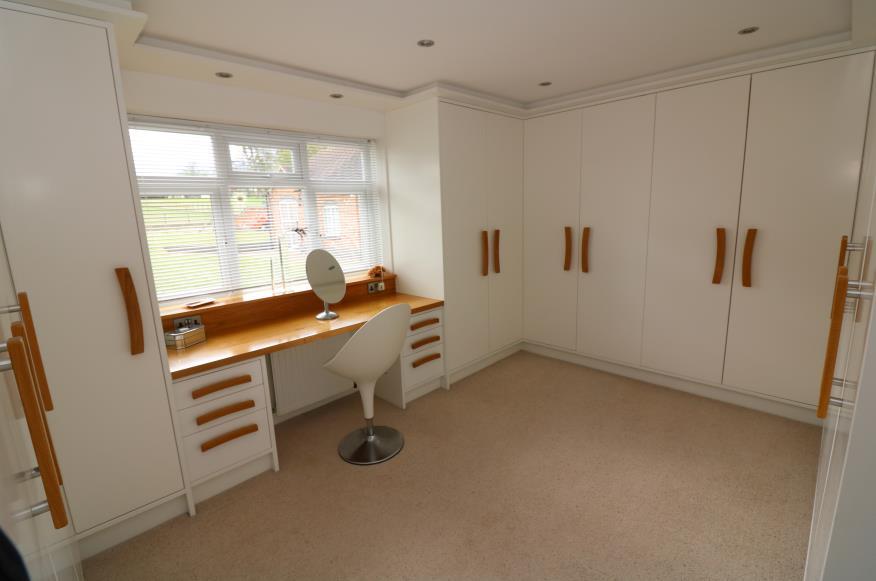 05m) minimum, with built-in wardrobe cupboards to all walls. Fitted dressing table, rear elevation double glazed window with blinds. Multi socket power points and inset ceiling lights.