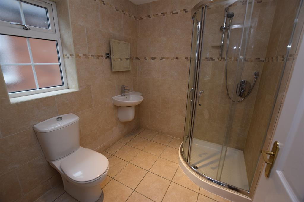 with white suite, tiled floor, tiling to all walls, large double Jacuzzi spa bath with built-in seats and side mounted chrome mixer tap and shower attachment, large corner shower with glazed sliding