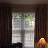 One chrome curtain pole with two finials ball ends and two decorative pale brown lined curtains with silver coloured tree
