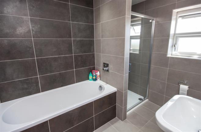 FAMILY BATHROOM fitted with a white Vilroy & Boch suite incorporating a bath, shower cubicle with mains shower, floating toilet, hand basin, towel radiator, inset spotlights, Vilroy & Boch wall and